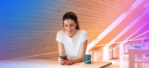 woman at the table is localizing her things using phone