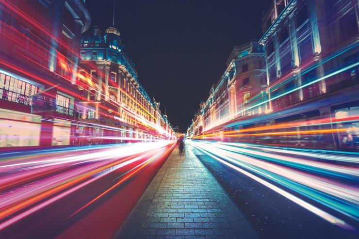 Timelapse street scene at night showing light streaks from passing cars